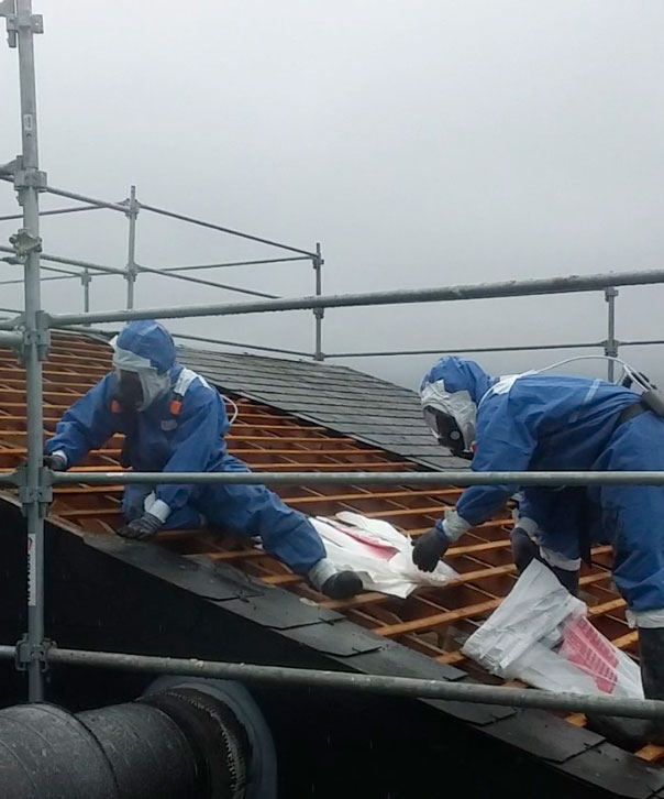 Equipes de SCAREV sur le toit d'une maison pour retirer les matériaux contenant de l'amiante